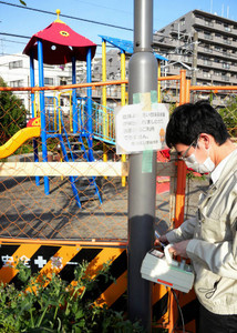 公園内の遊具付近の線量を測る区職員＝東京都豊島区の「池袋本町電車の見える公園」で